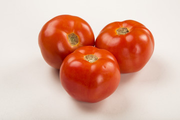 Some tomatoes over a wooden surface on a tomato field as backgro