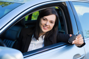 driving concept -happy smiling woman with car key