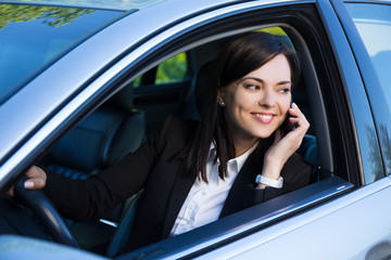 Fototapeta na wymiar happy successful business woman talking on phone in her car