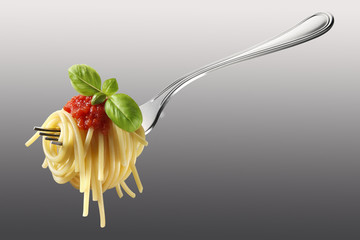 Forkful of spaghetti with tomato and basil