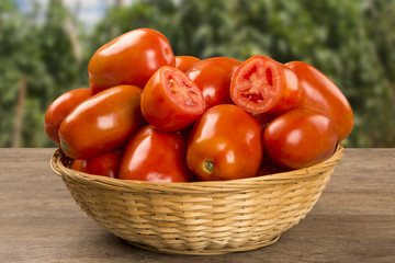 Some tomatoes over a wooden surface on a tomato field as backgro