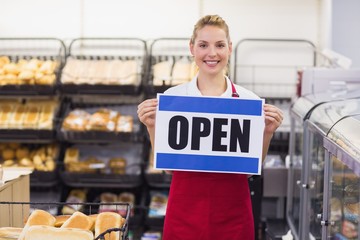 Portrait of a smiling blonde woman holding a sign