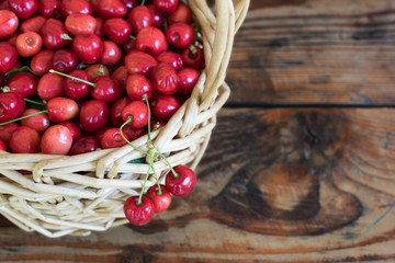 Ripe organic homegrown cherries in a basket, on wooden background