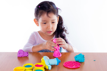 Little girl is learning to use colorful play dough on white background