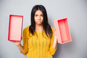Unhappy woman holding empty gift box