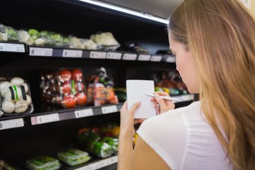 Woman writing in her notepad in aisle 