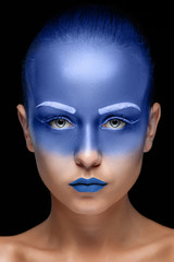 Portrait of a woman who is posing covered with blue paint