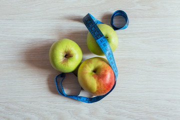 two green apples and red apple with measurement, top view. Conce