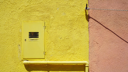 metal pipe and electric box on yellow color wall