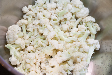 Closeup of cut cauliflower in stainless steel bowl