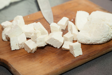 Closeup of paneer cut into pieces on cutting board