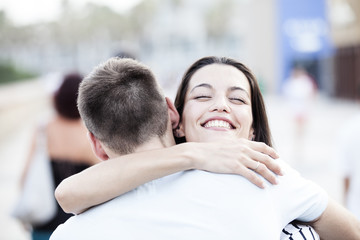 Happy teen couple embracing at street. Love concept