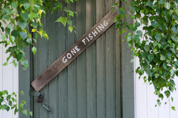 Gone Fishing sign at on old door