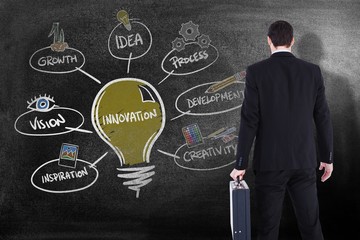 Composite image of rear view of businessman holding a briefcase