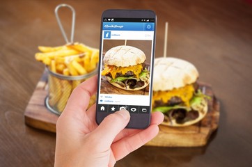 Composite image of female hand holding a smartphone