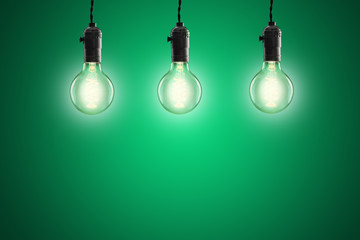 Idea concept - Vintage incandescent bulbs on green background