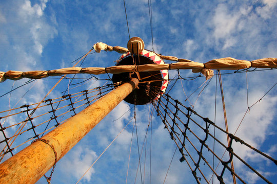 Sailing ship's furled canvas sails and complicated rope