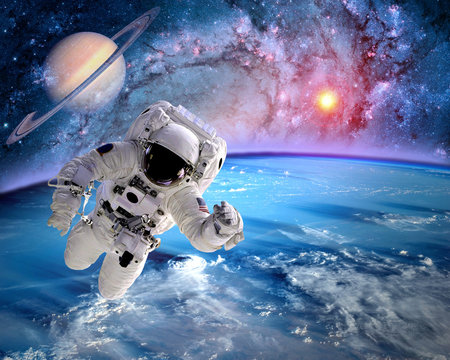 Astronaut spaceman outer space planet saturn earth sun universe. Elements of this image furnished by NASA.