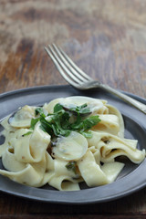 Pappardelle with white clamshells in white sauce.