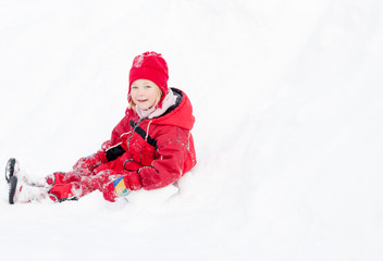 kleines Mädchen spielt im Schnee im roten Skianzug 2
