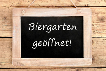 Fototapeta premium Holztafel Biergarten geöffnet