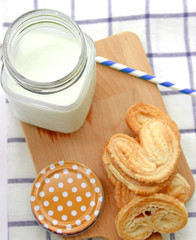 Breakfast set, glass of milk, snack on wooden plate
