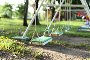 Old metal and wooden swing chair  on the playground in the park