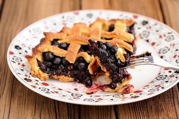 Piece of fresh homemade lattice pie with whole wild blueberries