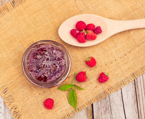 Fresh raspberries and jam on wooden table