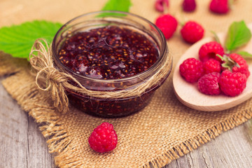 Fresh raspberries and jam on wooden table