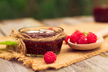 Fresh raspberries and jam on wooden table