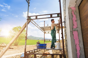 Naklejka premium Man putting natural stones on a wall