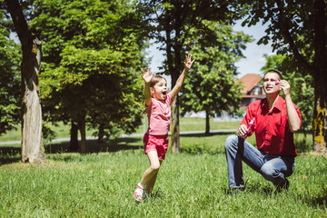 Dad and his daughter are making bubbles