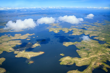 Aerial view to archipelago under few fluffy clouds 