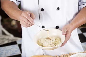 Chef cooking Noodle with seasoning sauce