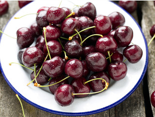 sweet cherry on a plate on wooden table