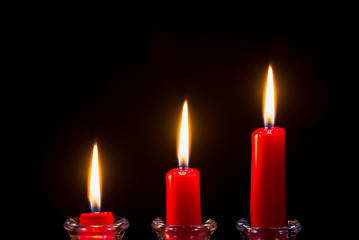 Three red candles on a black background