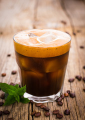 Ice coffee in a glass on the wooden table 