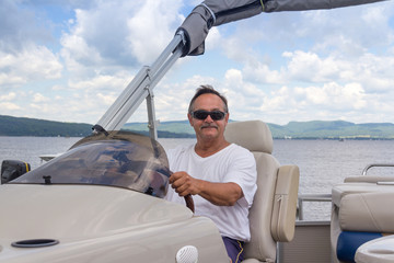 mature men driving a pontoon boat on a lake