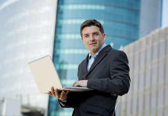 businessman holding computer laptop working outdoors