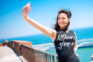 Loving to take pictures of herself, girl smiling and being happy while making selfie.