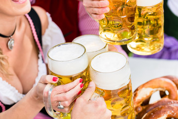 Anstoßen mit drei Maß Helles im Biergarten, Close-up auf die Biergläser