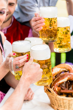 Anstoßen mit drei Maß Helles im Biergarten, Close-up auf die Biergläser