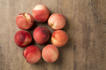 Some peaches in a basket over a wooden surface