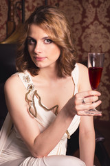 beautiful girl in retro interior with a glass of wine