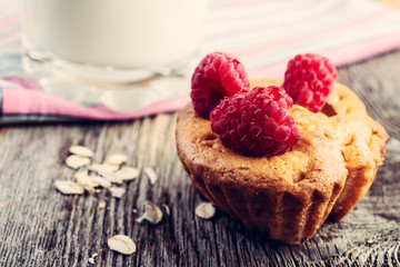 muffin with fresh  raspberry  and a peach milkshake  on a wooden table.