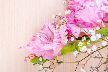branch of pink gladiolus on wooden table. Vintage flower background. Soft focus.
