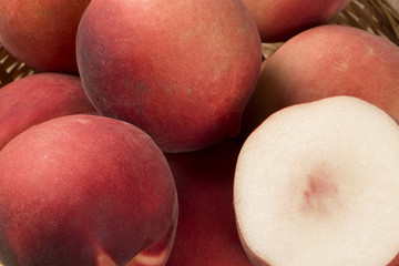 Some peaches in a basket over a wooden surface