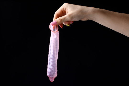 Extended red condom in the hand