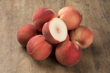 Some peaches in a basket over a wooden surface